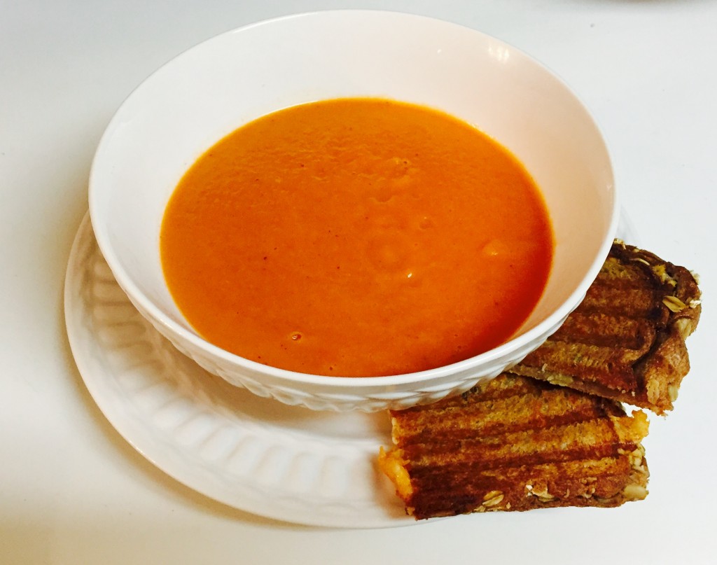 Sweet tomato soup served with grilled cheese